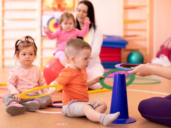 Nursery babies group doing sport in gym